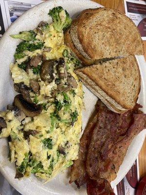 Broccoli mushroom American cheese egg scramble with bacon and rye toast