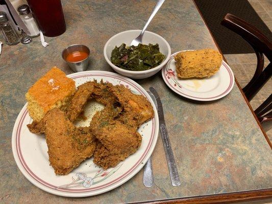 Fried chicken wing dinner w Greens w turkey, corn bread an fried corn on the cob.