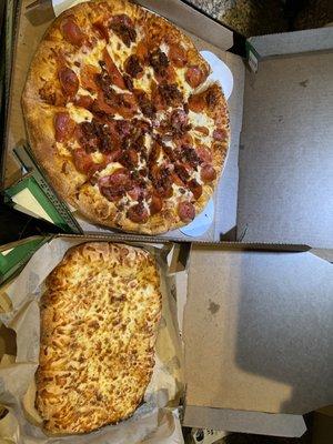 Pepperoni and bacon pizza with breadsticks and cheese sauce