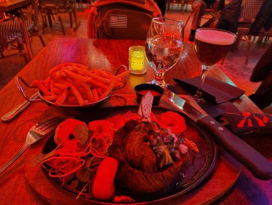 Skirt steak and shrimp with fries and a very small cocktail that is smaller than it appears in this photo.