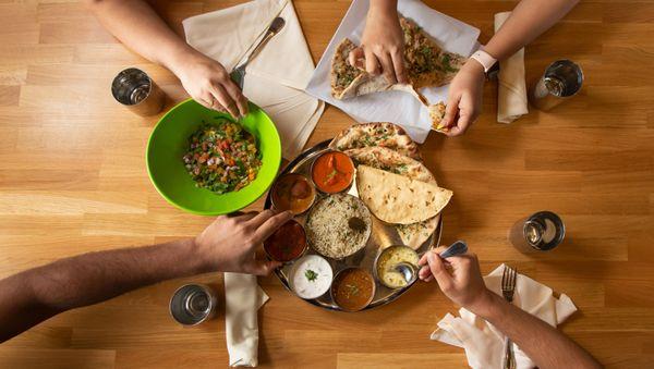 Tulsi Thali Combo. Choice of Three Curries, 1 Daal, 1 Bread, 1 Rice, 1 Appetizer, and 1 Dessert with a Side of Papaddum, Raita & Pickle.