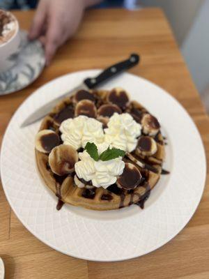 Waffle with bananas & house nutella drizzle, topped with whipped cream and mint leaf