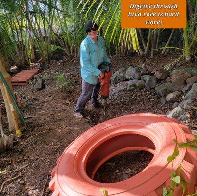 Our handyman digging through Lava rock to make the tire playground