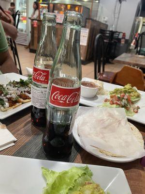 Coke served by the bottle. Next to freshly heated tortillas