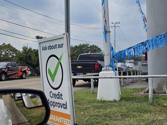 Illegal Signage and parking issue block line of sight at intersection.