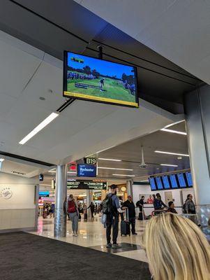 LIV Golf Houston 2024 Round 1 broadcast live on TV screens inside Concourse B. Gate B19.