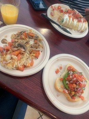 Loaded hash brown, avocado toast and mimosa . Veggie breakfast burrito in back.