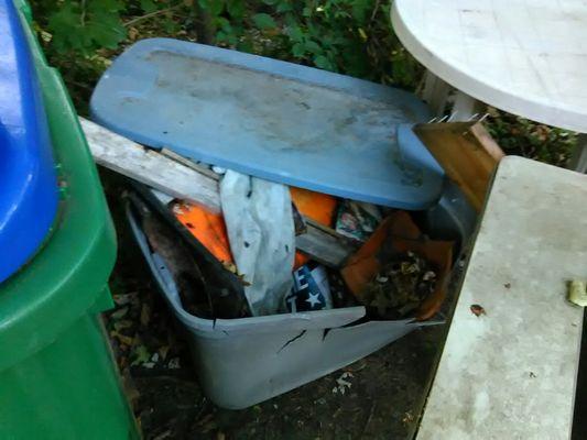 Shattered storage container and contents of junk and garbage formerly strewn about front of 3106 Stuart Ave.