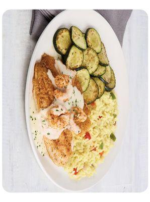 New Orleans seafood is a flight of tilapia.jumbo shrimp with black and seasoning and Alfredo sauce and serve with rice and grill zucchinis