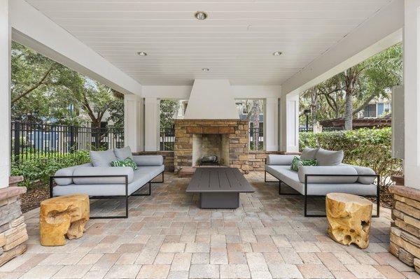 Image of Lantower Cypress Creek's fireplace area with a stone fireplace, coffee table, and stylish sofas.