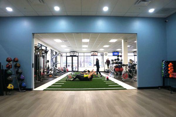 Interior image from our group fitness class looking out through our sliding doors to the functional group training area at FitMe Wellness.