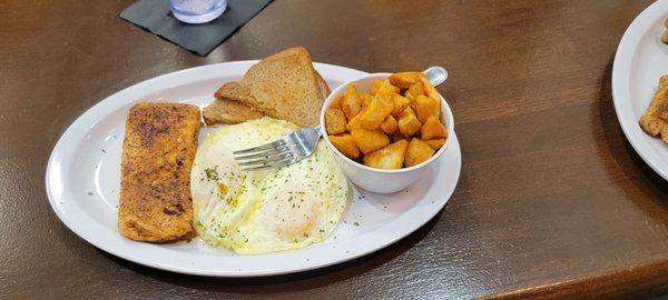 Grilled salmon,  over easy eggs, and potatoes with wheat toast.