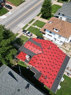 That is ice and water barrier on gutter lines & synthetic felt ready to keep the house water tight. Next, we load & shingle.