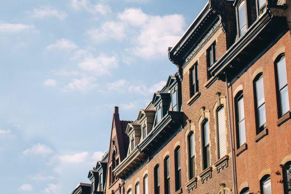 Philly brick rowhomes and cornices against blue sky