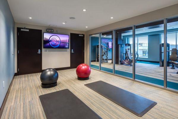 Pilatets, yoga, and stretching room with mats, yoga balls, and a TV.