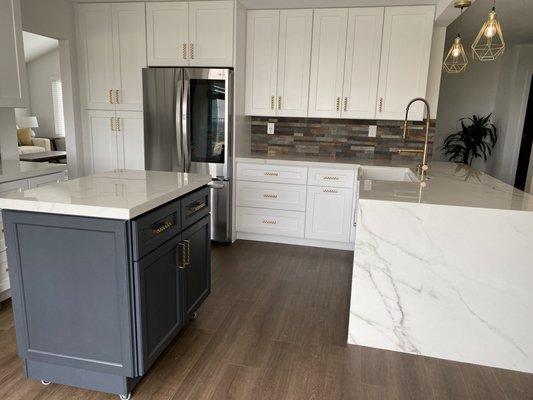 Maple Shaker painted White, Charcoal Navy Island on Castors, Honey Bronze fixtures, polished Porcelain countertops & rustic tile backsplash