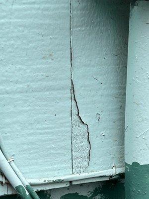 Paint flaking off the side of the house