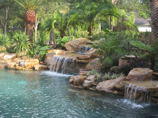 Pool waterfall and tropical landscaping in South Florida. Landscape design by Matthew Giampietro