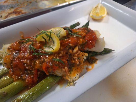 Baked cod with tomato,basil and lemon sauce On grilled asparagus.