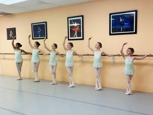 Students of Almayeva Ballet Academy holding correct position at the ballet bar