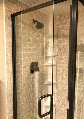 Subway tile look Roman Stone shower, with oil rubbed bronze fixtures and glassware. Beautiful.