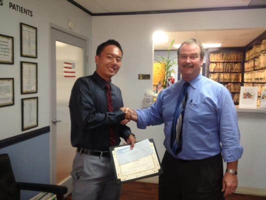 Dr. Tozzer awarding Irvine High School student with $1,000 college scholarship