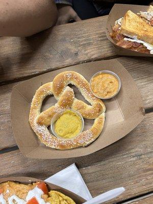 Pretzel with mustard and queso