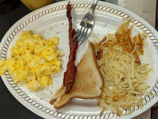 Scrambled eggs with bacon and hash browns. No seasoning