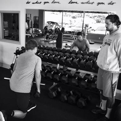 Trainer Connor Houston working with a client on dumbbell lunges.