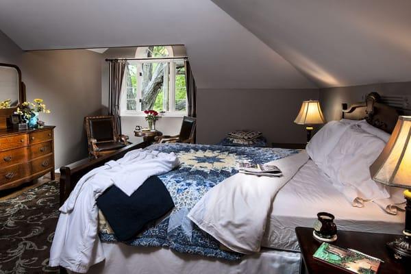 White Oak guestroom with a Queen bed and sitting area overlooking the huge old tree