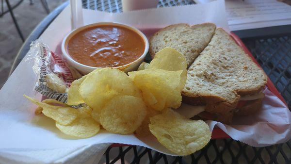 Deli turkey sandwich with a cup of red pepper Gouda soup