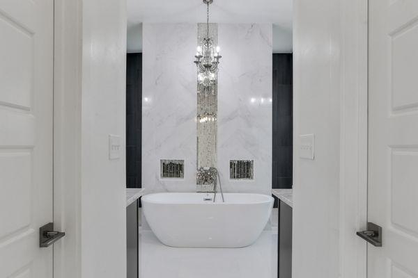 Designer finishes with marble deco wall and antique mirrored waterfall tiles with garden tub & crystal chandelier.