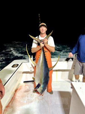 Stud fisherman and deck hand with a yellow fin tuna