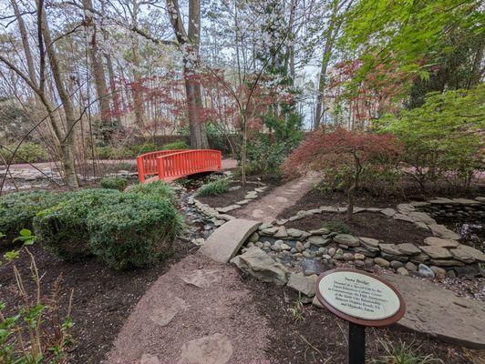 This is a marker commemorating the stone bridge and a view of that bridge.  Photo taken March 25, 2023.