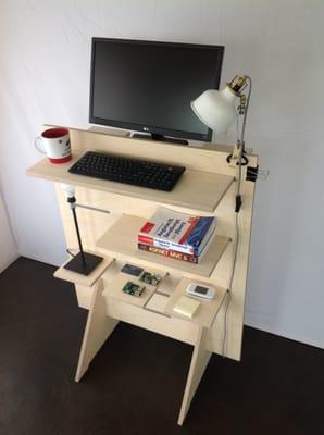 Half-sized standing desk with shelving, also available on wheels.