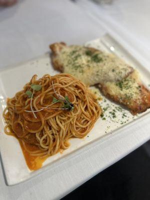 CHICKEN PARMIGIANA Breaded and gratin chicken milanesa with Pomodoro and mozzarella cheese, served with spaghetti Pomodoro