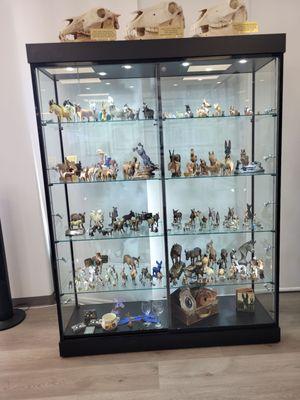 Several curio cabinets with donkey and mule figurines.