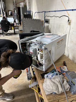 Sean repairing a microwave in Olathe, Kansas