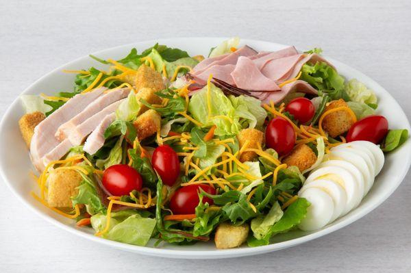 Celebrity Chef Salad, topped with turkey breast, ham, Cheddar cheese, tomato, hard‑boiled egg and seasoned croutons on healthy mixed greens