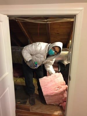 Cutting R-30 insulation to fit and seal attic space.