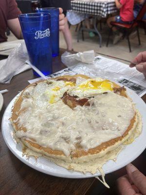 Making a breakfast taco out of one huge pancake, they don't 3 slices of bacon, sausage gravy and two eggs over easy.