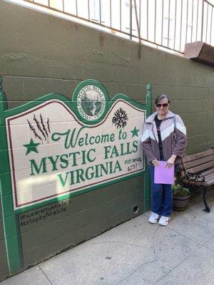 Me by the painted Welcome to Mystic Falls sign before getting on our tour