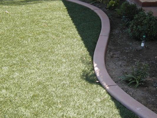 Concrete curb separating lawn from planter