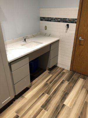 3x6 white subway wall tile w/ glass mosaic accent. 6x36 porcelain wood look plank floor tile.