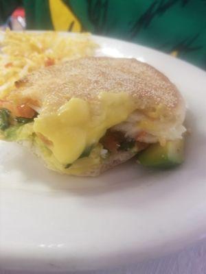 Avacado egg white sandwich with hash browns .