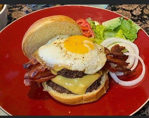 Ultimate Burger 2-1/4 beef patties, bacon, topped with sunny side up egg on a pretzel bun.