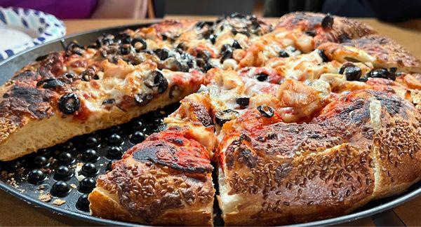 Olive and cheese pizza - medium thick crust. Sesame seeds come standard on the crust.