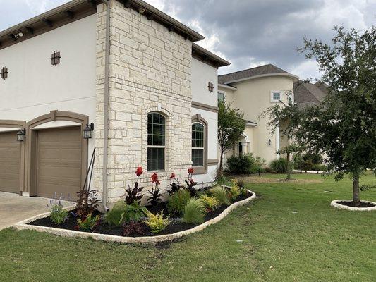 Installed stone edging, removed old damaged plants/mulch, and planted new plants/mulch