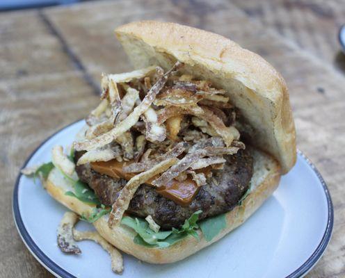 Fenrir Burger - blend of dry-aged ground beef & grass-fed lamb grilled with melted brunøst, oil cured tomato jam, arugula, & crispy onions