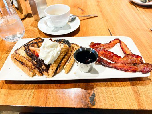 French toast topped with whipped cream, blueberries, & strawberries.  Comes with three slices of bacon.